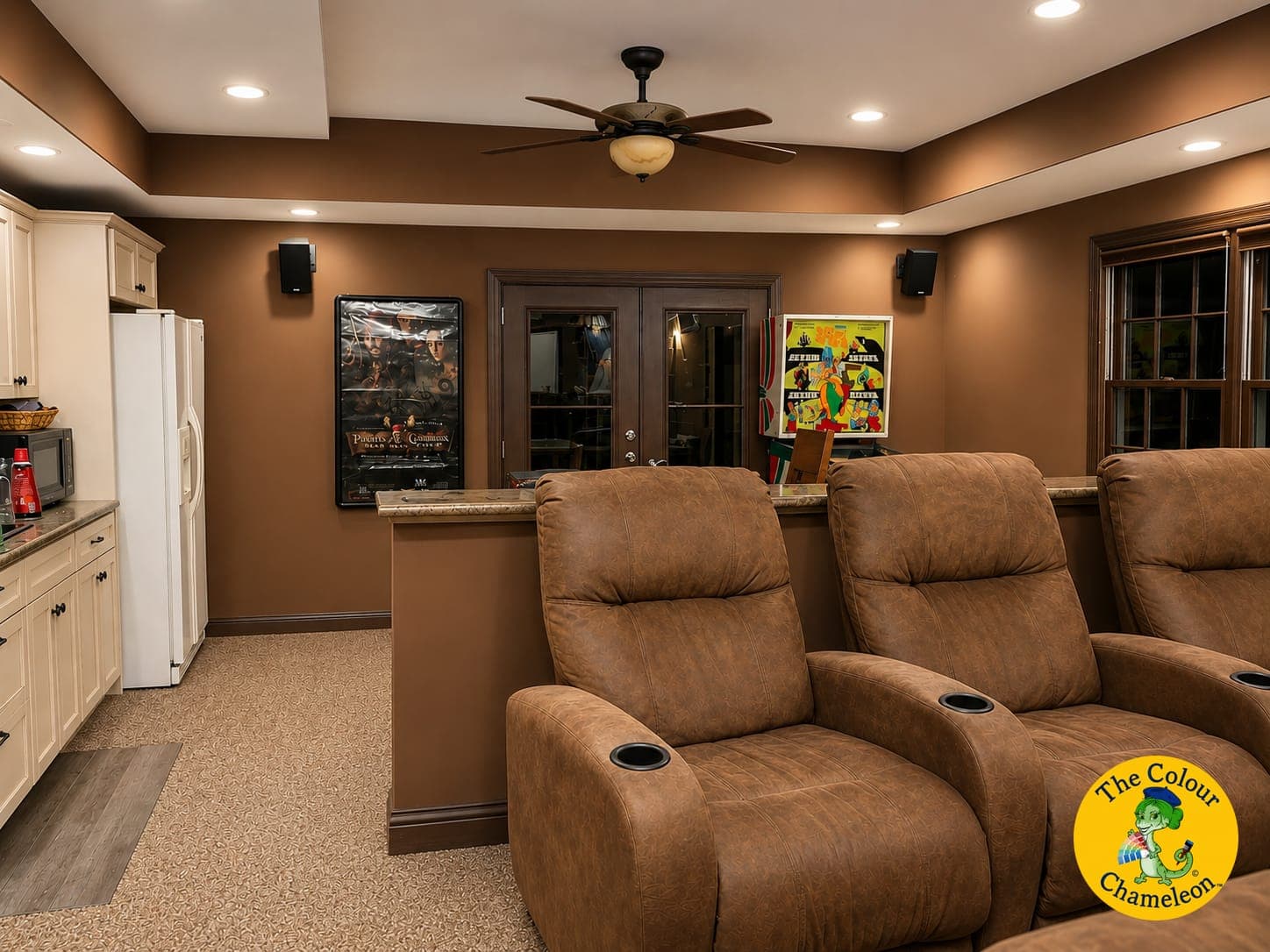A basement in chocolate brown walls and ceiling with brown leather recliners