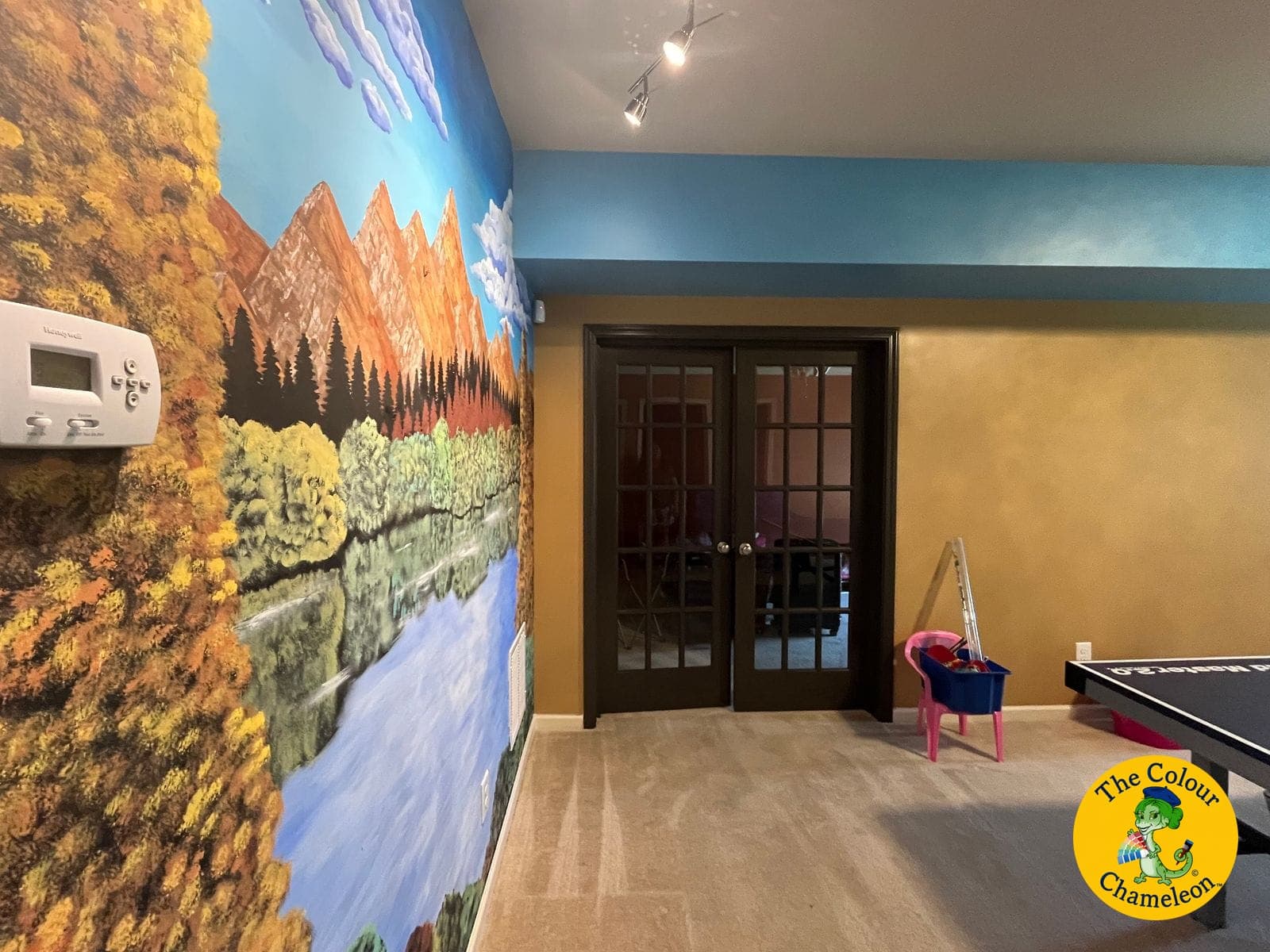 The mural wall with the upper wall painted sky blue and the lower wall warm gold