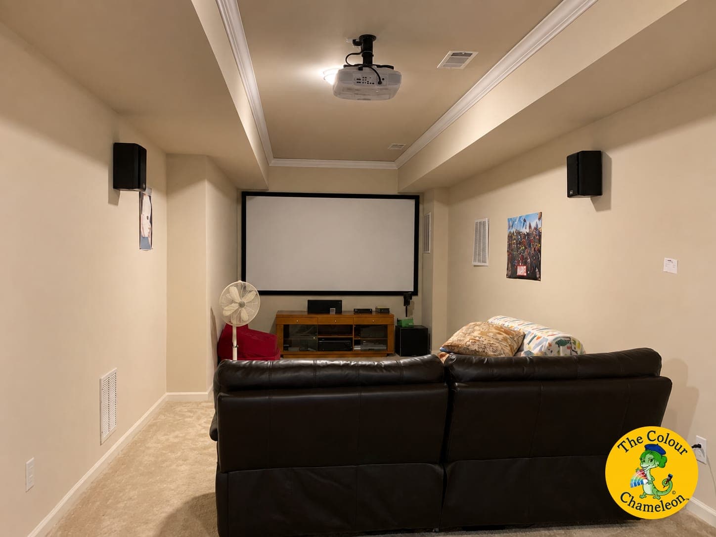 A basement theater room in flat cream with a projection screen