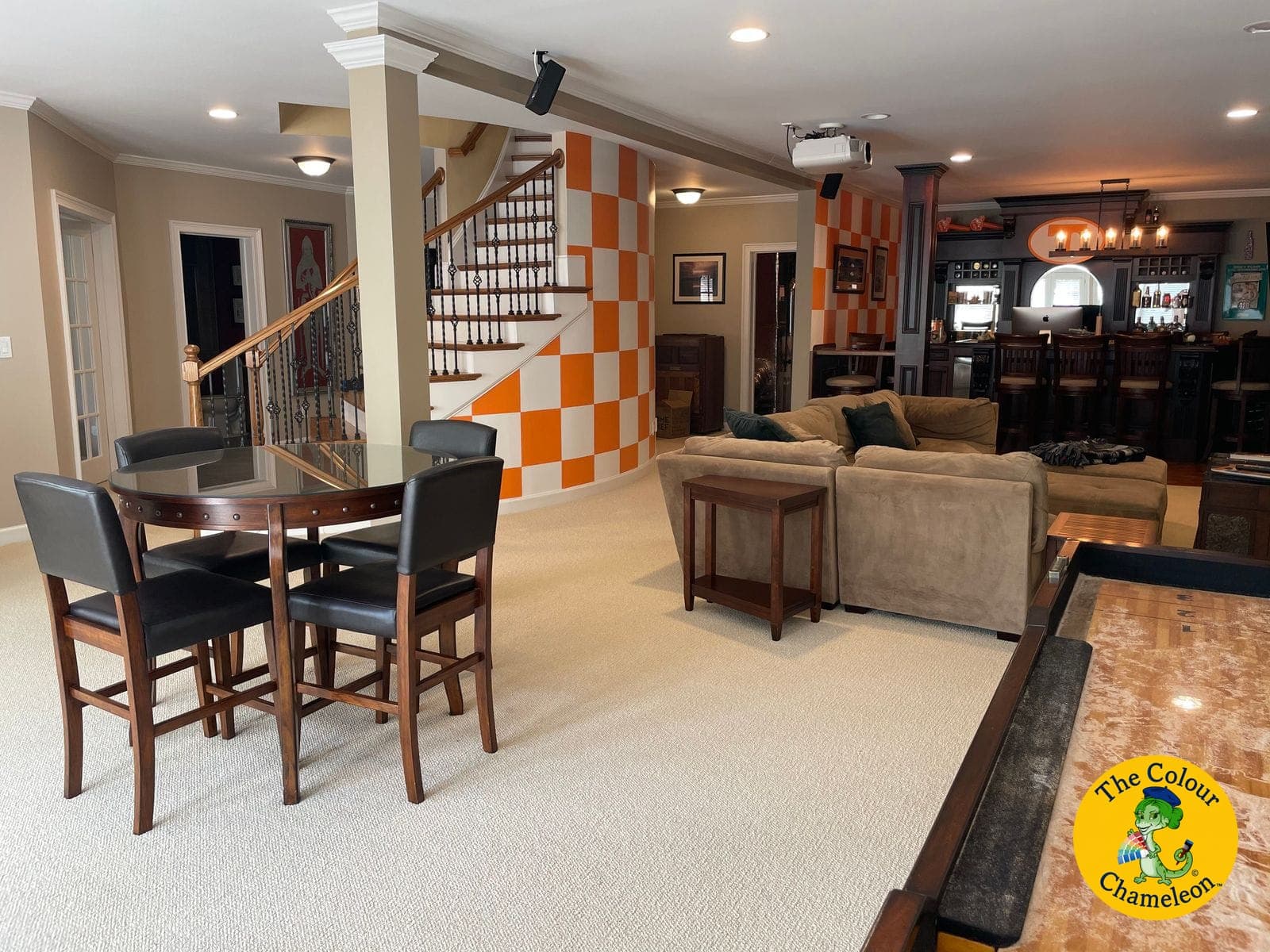 The same basement in taupe with an orange-and-white checkerboard wall by the stairs