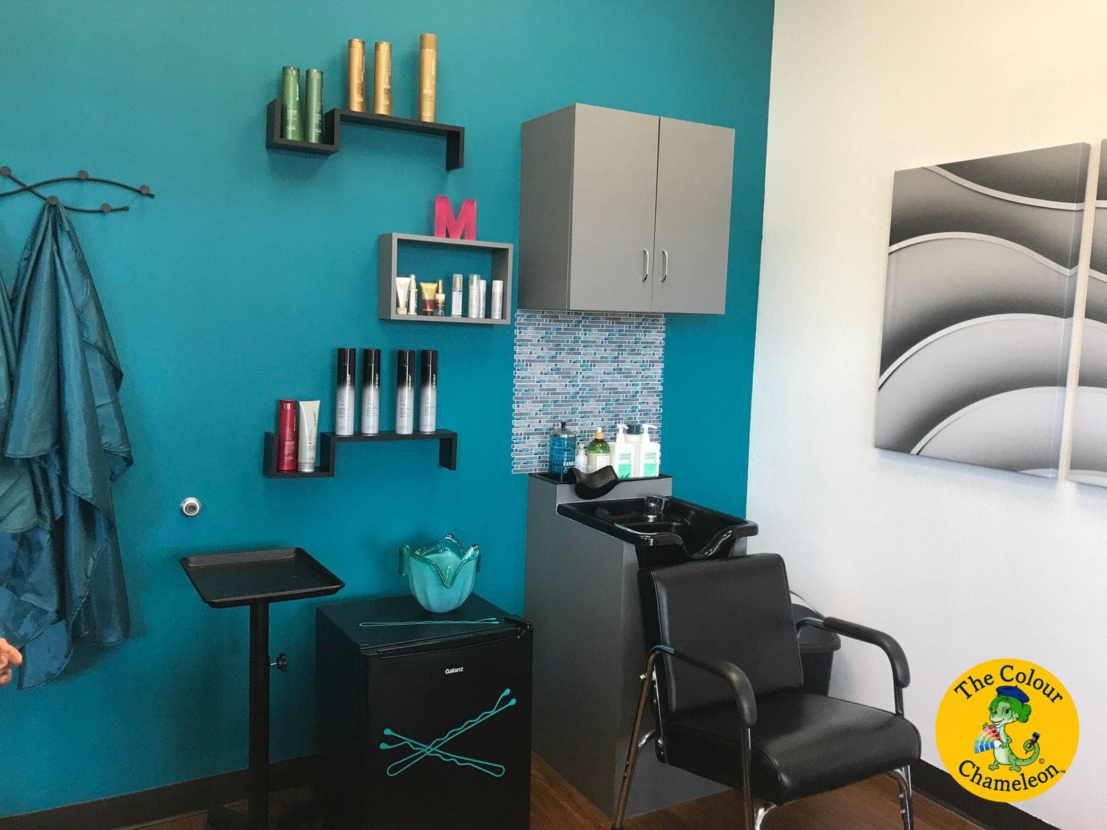 The same suite with a vibrant teal accent wall, gray cabinetry and a mosaic tile backsplash