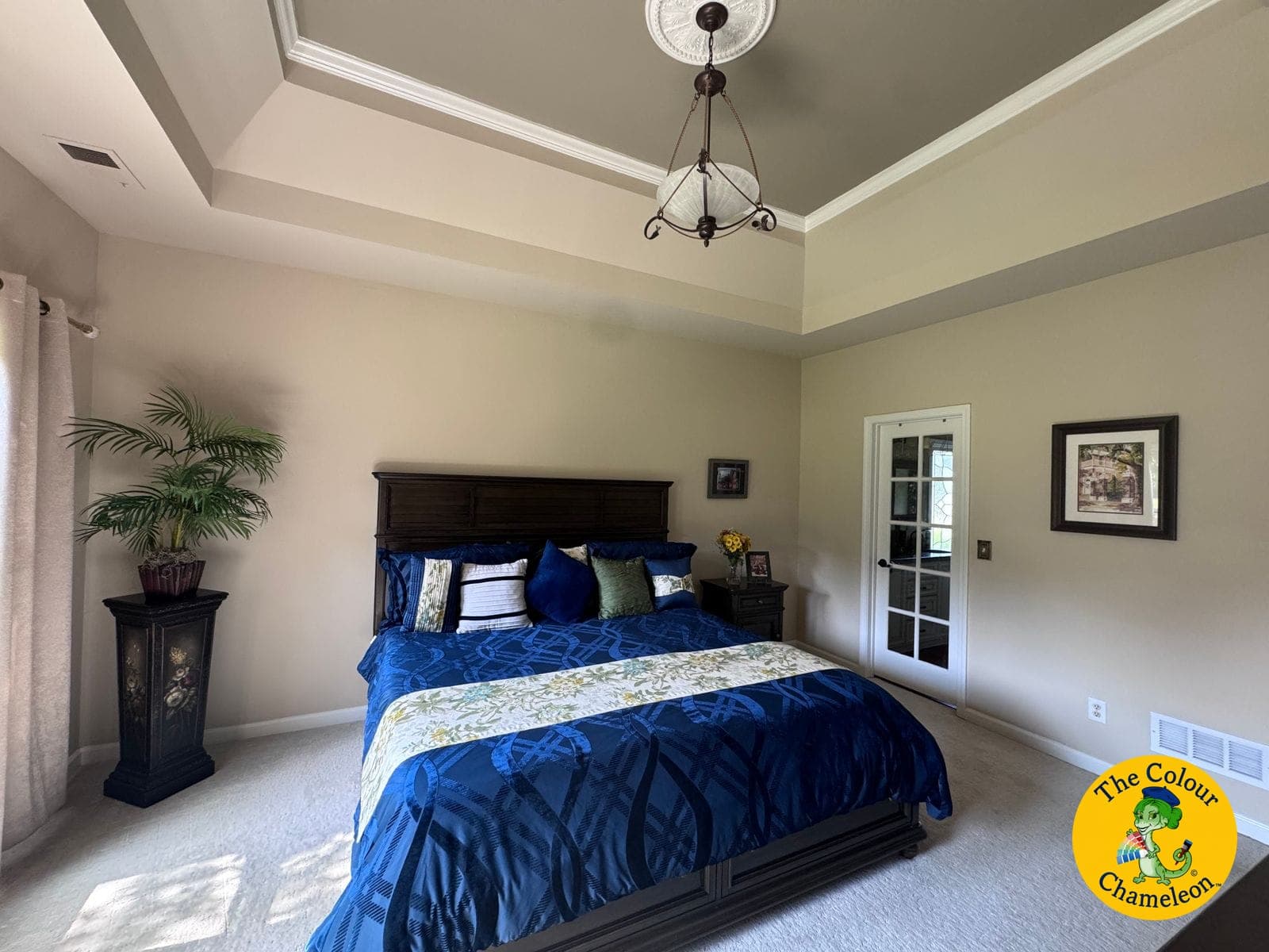 The same bedroom in soft green with blue and green bedding under the tray ceiling