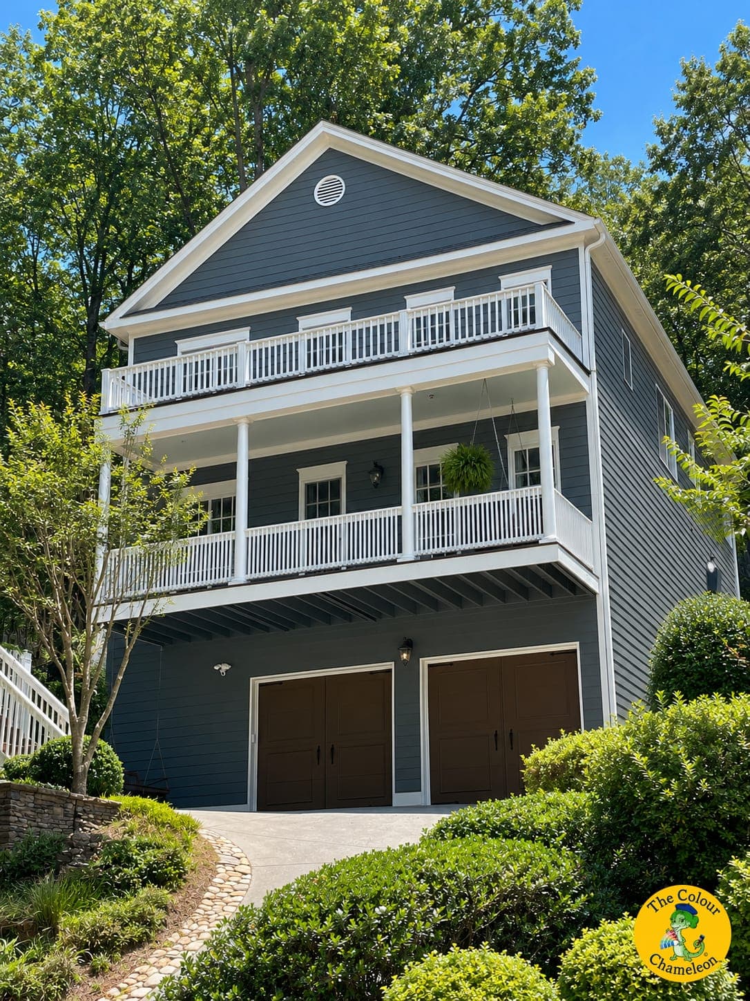 The same house in deep navy siding, the white railings and brown garage doors kept