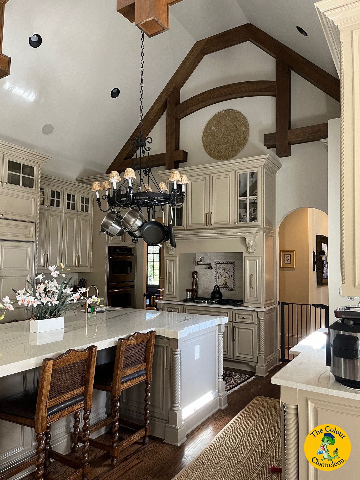 The same kitchen with the cabinets and island painted light taupe, the beams left stained