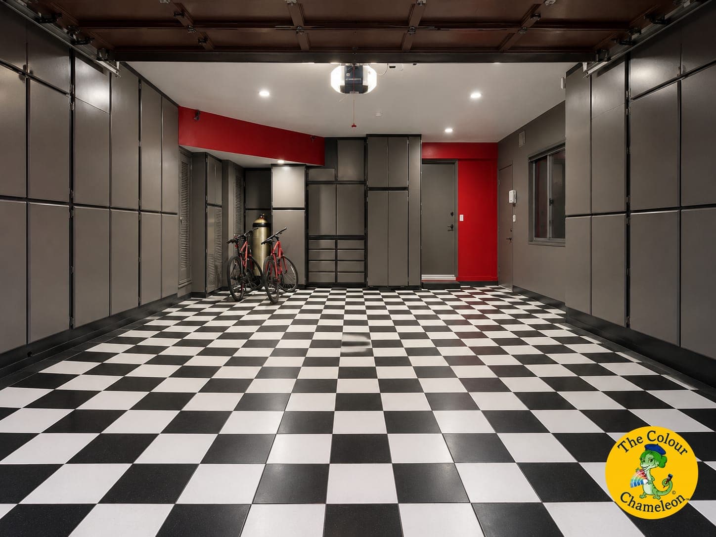 The same garage with graphite cabinets and a red accent wall above the checkered floor