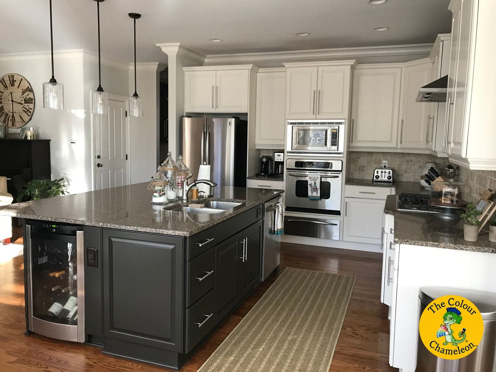 The same kitchen with white perimeter cabinets and a charcoal island