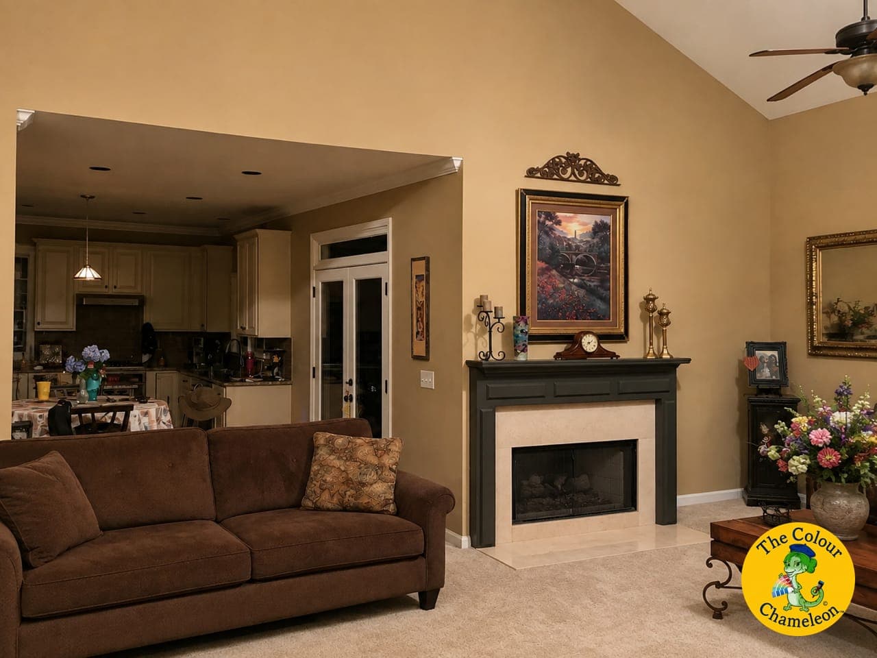 A living room in gold walls with a dark painted mantel and a brown sofa