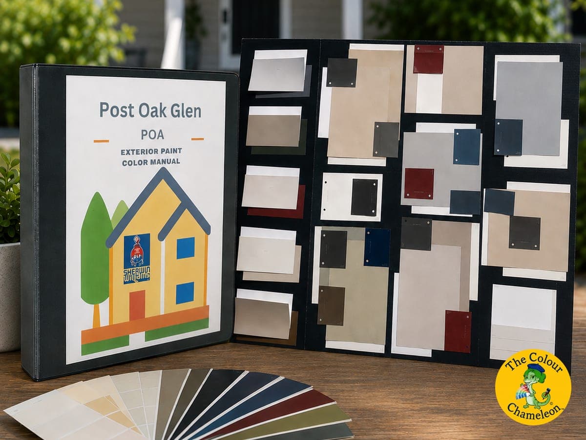 A Post Oak Glen POA exterior paint color manual open beside a mounted board of approved community color chips, with a fanned set of exterior color strips on a table
